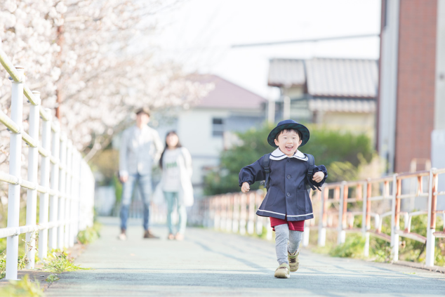 桜並木の道を走る子ども